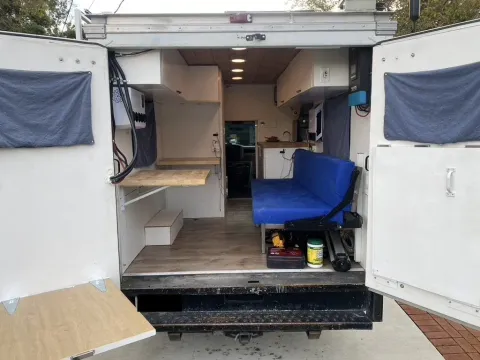 Rear partially folded out. Couch folds down into a bed. Rear doors have folding rear tables.